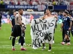Argentina's Giovani Lo Celso holds the banner.