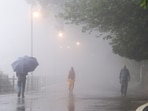 Shimla: People take a walk through dense fog on a rainy monsoon evening, in Shimla, Himachal Pradesh,.