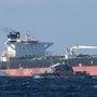 A French Navy vessel sails by the Russian oil tanker “Tagor”, suspected of flying a false Cameroonian flag and boarded by the French Navy on May 31 as it arrives in Douarnenez Bay, western France on June 2. (AFP)(HT_PRINT)