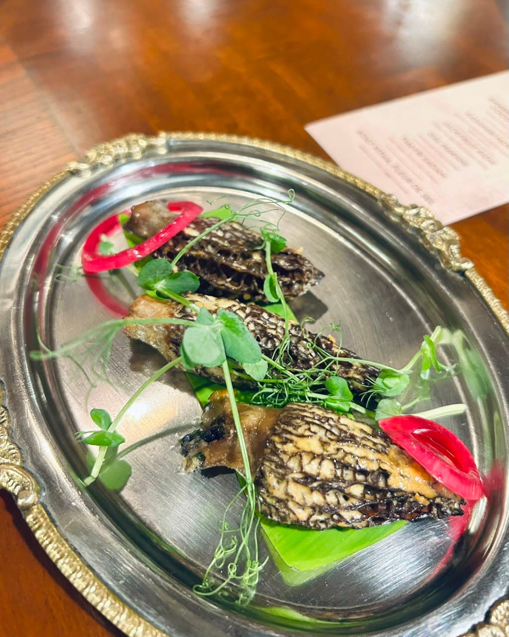 Earthy tandoori Kashmiri morels served on a banana leaf lining, finished with a subtle apple reduction and delicate microgreens. (Pic: Sanya Panwar) Earthy tandoori Kashmiri morels served on a banana leaf lining, finished with a subtle apple reduction and delicate microgreens. (Pic: Sanya Panwar)