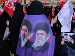 A mourner wears a banner showing portraits of the late Iranian Supreme Leader Ayatollah Ali Khamenei, right, and his son Ayatollah Mojtaba Khamenei, the successor to him, in a ceremony commemorating the late leader at the Imam Khomeini Mosalla Grand Mosque in Tehran, Tuesday, July 14, 2026.