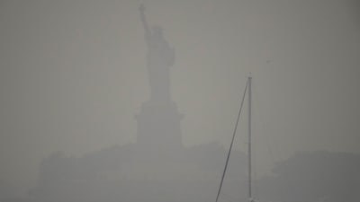 The Statue of Liberty is hardly visible as smoke from wildfires blankets the sky, (AP) The Statue of Liberty is hardly visible as smoke from wildfires blankets the sky, (AP)