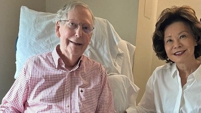 U.S. Sen. Mitch McConnell (R-KY) sits with his wife, former U.S. Labor Secretary Elaine Chao, holding what appears to be a July 12 sports section issue of The Washington Post, published by his office in Washington, D.C. (Reuters)