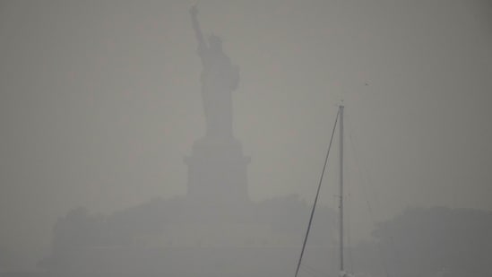 The Statue of Liberty is hardly visible as smoke from wildfires blankets the sky,