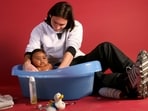 20-year-old soccer star Lionel Messi bathes baby Lamine Yamal. 