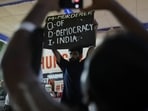 Abhijeet Dipke, head of the Cockroach Janta Party (CJP), holds a banner during an indefinite hunger strike after authorities took Sonam Wangchuk(REUTERS)