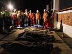 People pray next to the bodies of four victims of the earthquake of magnitude 5.6 that struck Central Peru on Saturday.