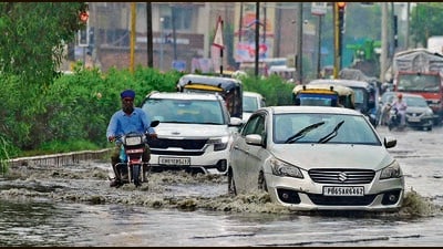 Commuters make their way through a waterlogged road in Ludhiana following heavy rain on Sunday. (Gurpreet Singh/HT) Commuters make their way through a waterlogged road in Ludhiana following heavy rain on Sunday. (Gurpreet Singh/HT)