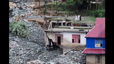 People stand near a house damaged due to a flash flood, in Poonch. (REUTERS) People stand near a house damaged due to a flash flood, in Poonch. (REUTERS)