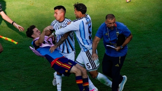 Spain's Gavi falls as he scuffles with Argentina's Leandro Paredes (5) and Thiago Almada after World Cup final.