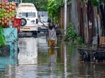 A female walks through a waterlogged path after a fresh spell of rainfall, in Srinagar on Sunday. (ANI)