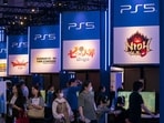 Visitors walk in front of the booth for Sony's PlayStation.