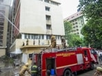 Fire personnel conduct a dousing operation after fire broke out at the 12-storey Jawahar Bhawan government building, in Lucknow, on Monday. (PTI Photo)