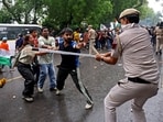 A policeman wields his baton against demonstrators following a clash during a march by supporters of Cockroach Janta Party towards Parliament on the opening day of its Monsoon Session, demanding the resignation of education minister Dharmendra Pradhan over exam paper leaks, near Jantar Mantar in New Delhi on July 20, 2026.