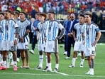 Argentina's Lionel Messi, Nicolas Otamendi, Rodrigo De Paul and Enzo Fernandez look dejected with teammates.