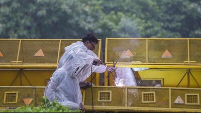 A worker carries out welding work on a barricade ahead of the Cockroach Janata Party's protest march at the Jantar Mantar in New Delhi on Monday. (PTI)