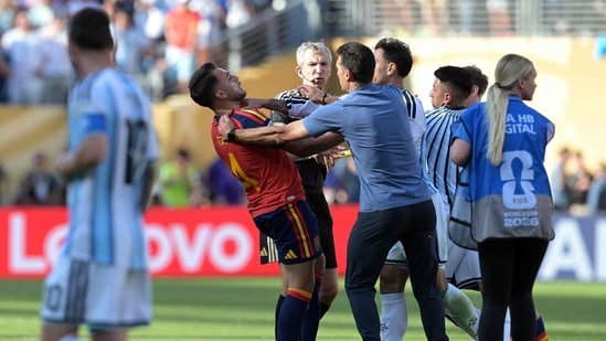 Argentina's head coach Lionel Scaloni (C,R) tries to intervene as Argentina's midfielder #05 Leandro Paredes clashes with Spain's defender #04 Eric Garcia.