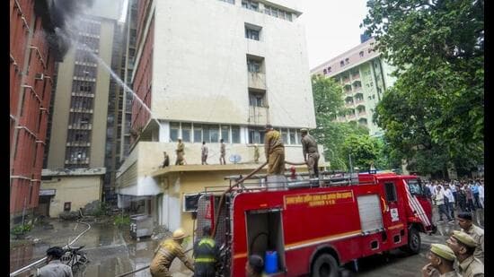 Fire personnel conduct a dousing operation after fire broke out at the 12-storey Jawahar Bhawan government building, in Lucknow, on Monday. (PTI Photo)