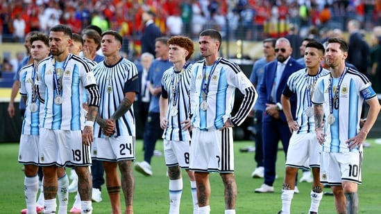 Argentina's Lionel Messi, Nicolas Otamendi, Rodrigo De Paul and Enzo Fernandez look dejected with teammates.