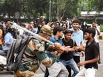 A security official carries out Lathi charge on protestors during their protest march towards Parliament called by Cockroach Janta Party demanding the resignation of Union Education Minister Dharmendra Pradhan over alleged NEET exam irregularities, near Jantar Mantar in New Delhi on Monday.