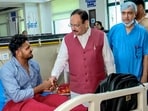 Union Health Minister JP Nadda interacts with a person injured during Monday's protest.
