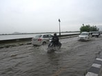 People travelling through a waterlogged road during heavy rainfall in Srinagar. (Waseem Andrabi/HT)