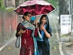 Two pedestrians seen sharing an umbrella amid the downpour in Chandigarh on Monday. (KESHAV SINGH/HT)