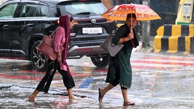 Gram it: Making their way through water-logged streets were these commuters at Kadipur Road in Gurugram. As monsoon showers lashed the city on Tuesday, NCR residents took to umbrellas and raincoats to make it through the day. IMD has predicted light to moderate rainfall accompanied by strong winds for today as well. (Photo: Parveen Kumar/HT)