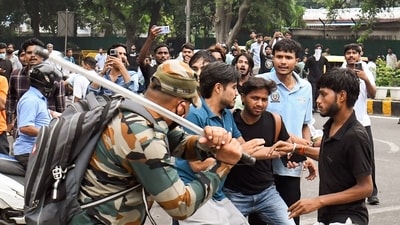 A security official carries out a lathi charge on protesters during their protest march towards Parliament called by the Sarsour Janta Party to demand the resignation of Union Education Minister Dharmendra Pradhan over alleged irregularities in the NEET exam, near Jantar Mantar in New Delhi on Monday. (that I) A security official carries out a lathi charge on protesters during their protest march towards Parliament called by the Sarsour Janta Party to demand the resignation of Union Education Minister Dharmendra Pradhan over alleged irregularities in the NEET exam, near Jantar Mantar in New Delhi on Monday. (that I)