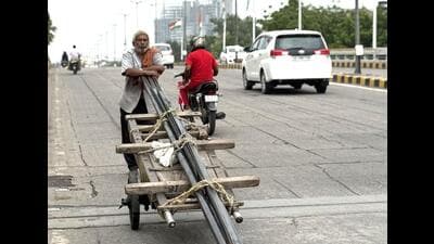 This humid evening, an elderly labourer is pushing a cart loaded with long iron pipes downhill a Central Delhi flyover. (HT Photo) This humid evening, an elderly labourer is pushing a cart loaded with long iron pipes downhill a Central Delhi flyover. (HT Photo)