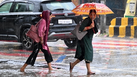 Gram it: Making their way through water-logged streets were these commuters at Kadipur Road in Gurugram. As monsoon showers lashed the city on Tuesday, NCR residents took to umbrellas and raincoats to make it through the day. IMD has predicted light to moderate rainfall accompanied by strong winds for today as well.