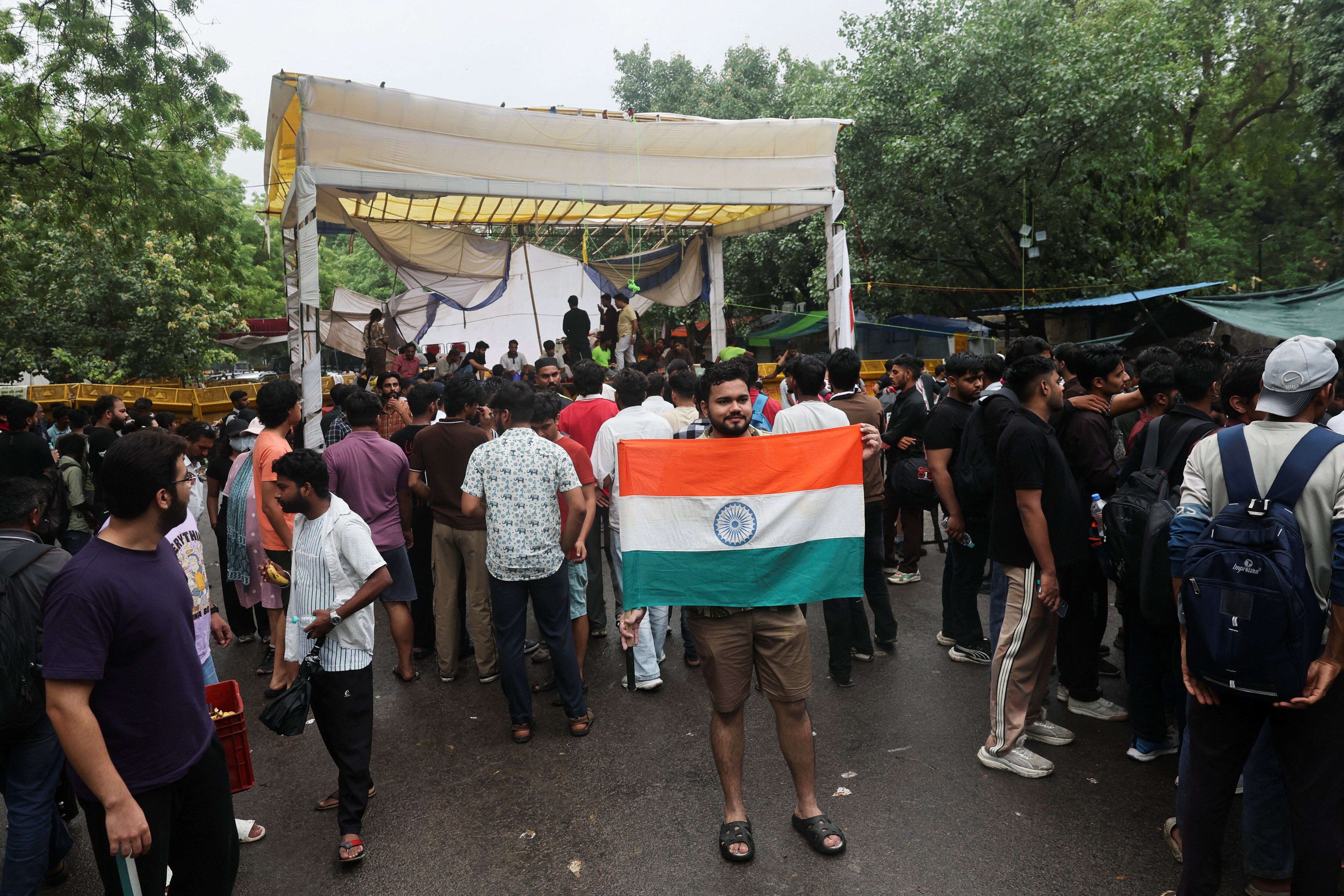A protester poses for a picture while holding the national flag at Jantar Mantar. (REUTERS)