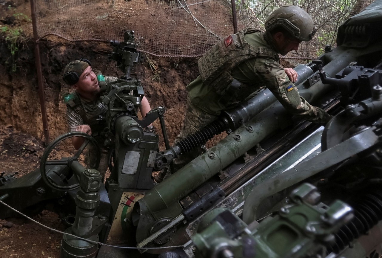 Ukrainian soldiers prepare to fire an M777 howitzer.