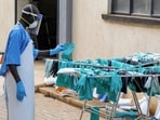 A Ugandan worker collects a rubber glove from the airing line during a visit by the Director-General of the World Health Organisation (WHO) Tedros Adhanom Ghebreyesus at the Mulago National Referral Hospital Isolation Unit.