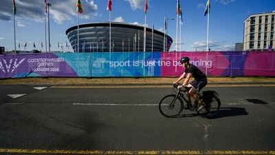 A cyclist passes participating nations' flags ahead of the Commonwealth Games 2026, in Glasgow, Scotland, Monday, July 20, 2026 (PTI) A cyclist passes participating nations' flags ahead of the Commonwealth Games 2026, in Glasgow, Scotland, Monday, July 20, 2026 (PTI)