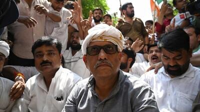 UP Congress president Ajay Rai sat on the road in protest after police stopped workers using barricades, in Lucknow on Wednesday. (Mushtaq Ali/HT)