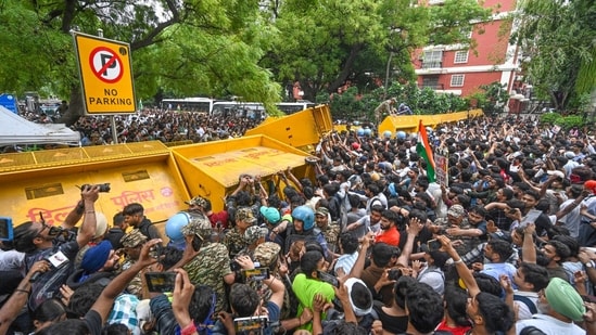 Scores of protesters attempt to breach through the security barricades at Jantar Mantar on Monday.