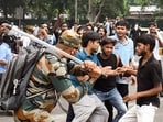 A security official carries out Lathi charge on protestors during their protest march towards Parliament called by Cockroach Janta Party demanding the resignation of Union Education Minister Dharmendra Pradhan over alleged NEET exam irregularities, near Jantar Mantar in New Delhi on Monday. 