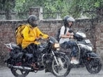 Commuters cover themselves as they make their way amid heavy rainfall, in Prayagraj on Thursday. (ANI Photo)