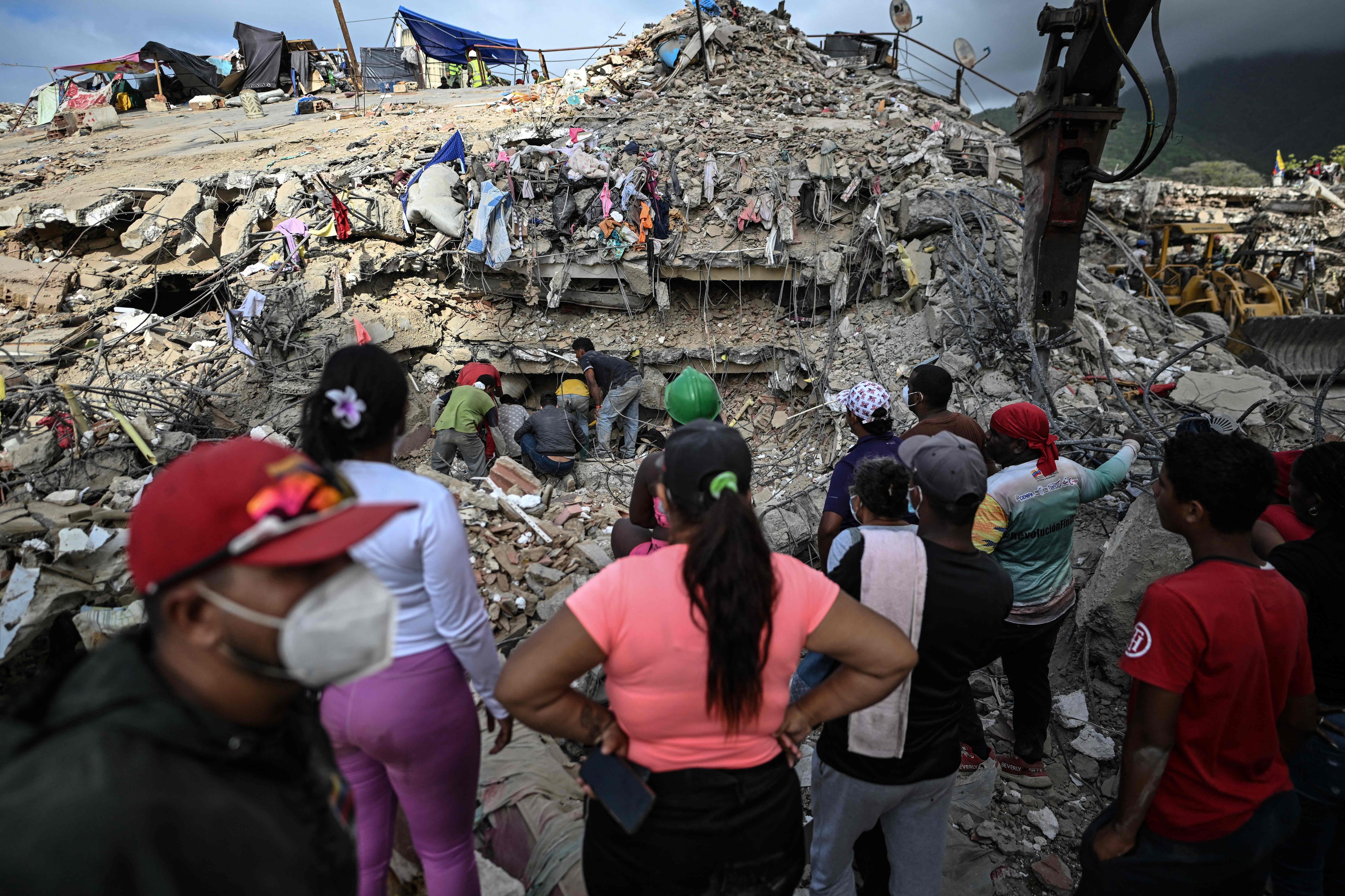 People search for bodies amid the rubble of a building in Caraballeda, Venezuela, on July 22, 2026, nearly a month after the June 24 earthquakes. (AFP) People search for bodies amid the rubble of a building in Caraballeda, Venezuela, on July 22, 2026, nearly a month after the June 24 earthquakes. (AFP)