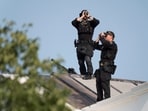 Members of the US Secret Service counter assault team scan the sky from the rooftop of the White House before President Donald Trump arrives back to the White House.