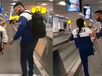 KS Ulhas helps Irengbam Ritu Chanu onto a flat escalator.