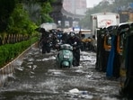 Motorists drive through waterlogged roads as heavy rains lash Mumbai.