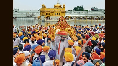 A Sikh priest carries Sri Guru Granth Sahib on his head at the start of the Miri Piri Khalsa march, organised by the SGPC from Akal Takht to commemorate the Miri Piri Diwas in Amritsar on Friday. (ANI) A Sikh priest carries Sri Guru Granth Sahib on his head at the start of the Miri Piri Khalsa march, organised by the SGPC from Akal Takht to commemorate the Miri Piri Diwas in Amritsar on Friday. (ANI)