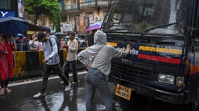 Rhea Ahir, a 27-year-old model, stands with her arms outstretched in front of a police car during a demonstration in solidarity with the RJD's agitation over alleged NEET violations, in Mumbai, Wednesday, July 22, 2026. (PTI) Rhea Ahir, a 27-year-old model, stands with her arms outstretched in front of a police car during a demonstration in solidarity with the RJD's agitation over alleged NEET violations, in Mumbai, Wednesday, July 22, 2026. (PTI)