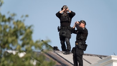 Members of the U.S. Secret Service Counterattack Team scan the sky from the White House rooftop ahead of President Donald Trump's return to the White House. (AP Photo/Manuel Balce Seneta)