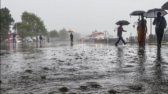 People walk amid rainfall in Shimla, Himachal Pradesh. (PTI)