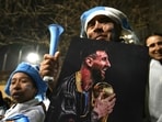 A fan holding a portrait of Argentina's forward Lionel Messi.