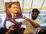 విద్యాశాఖ మంత్రి ధర్మేంద్ర ప్రదాన్ రాజీనామా అనంతరం బాబాసాహెబ్ అంబేడ్కర్ చిత్రపటాన్ని చూపుతున్న సీజేపీ నేత అభిజీత్ దిప్కే(REUTERS)