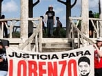 People hold signs in Hidalgo Park during a rally to protest the killing of Lorenzo Salgado Araujo in Houston, Texas, on July 24 (Photo by Mark Felix / AFP)